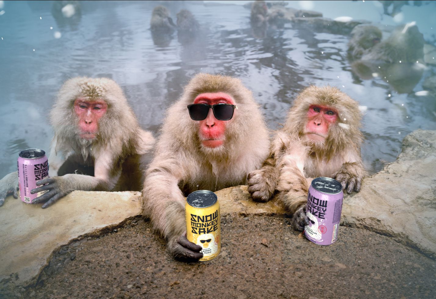 three monkeys in the hot springs, each holding a can of Snow Monkey Sake